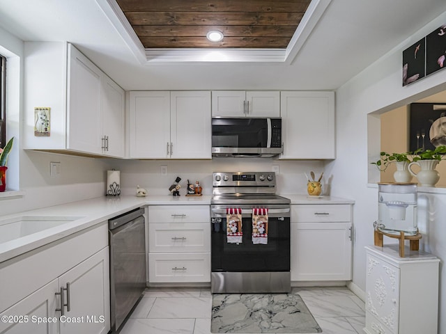 kitchen with a raised ceiling, white cabinetry, appliances with stainless steel finishes, and wooden ceiling