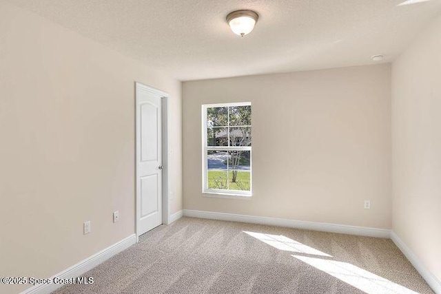 1581 San Filippo Dr SE, Palm Bay, FL 32909 - unfurnished room featuring light colored carpet, baseboards, a smoke detector, and a textured ceiling