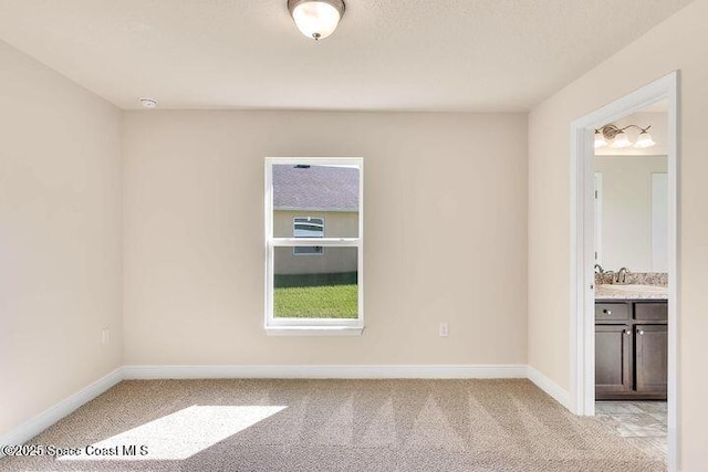 1581 San Filippo Dr SE, Palm Bay, FL 32909 - spare room with light carpet, baseboards, and a sink