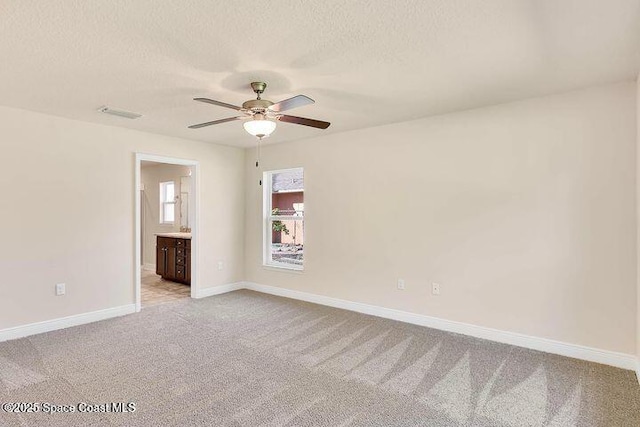 1581 San Filippo Dr SE, Palm Bay, FL 32909 - spare room featuring ceiling fan, light carpet, a textured ceiling, and baseboards