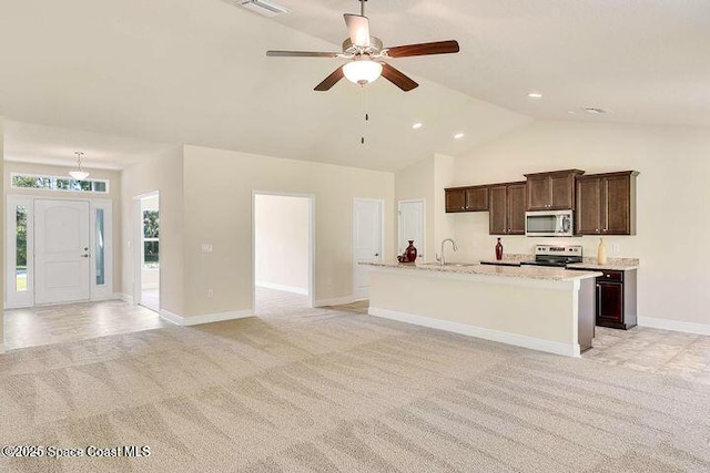 1581 San Filippo Dr SE, Palm Bay, FL 32909 - kitchen with appliances with stainless steel finishes, light carpet, a ceiling fan, baseboards, and high vaulted ceiling