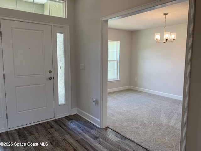 1581 San Filippo Dr SE, Palm Bay, FL 32909 - foyer featuring a chandelier, dark wood-style floors, and dark carpet