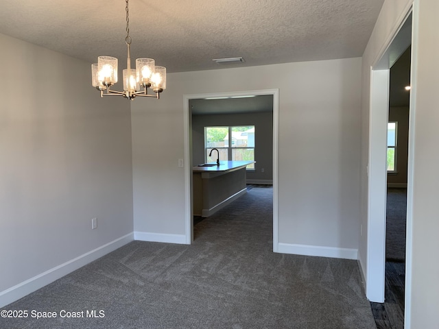 1581 San Filippo Dr SE, Palm Bay, FL 32909 - empty room with dark colored carpet, a textured ceiling, and a chandelier