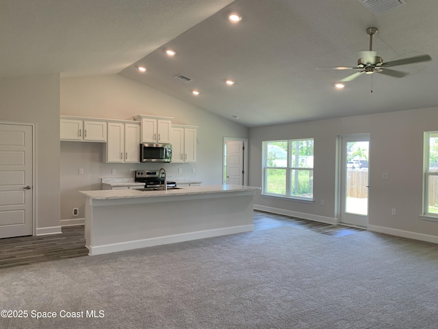 1581 San Filippo Dr SE, Palm Bay, FL 32909 - kitchen featuring stainless steel appliances, dark colored carpet, white cabinetry, recessed lighting, and open floor plan