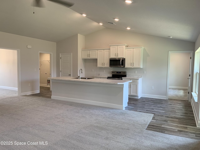 1581 San Filippo Dr SE, Palm Bay, FL 32909 - kitchen with stainless steel appliances, white cabinets, a kitchen island with sink, light countertops, and high vaulted ceiling