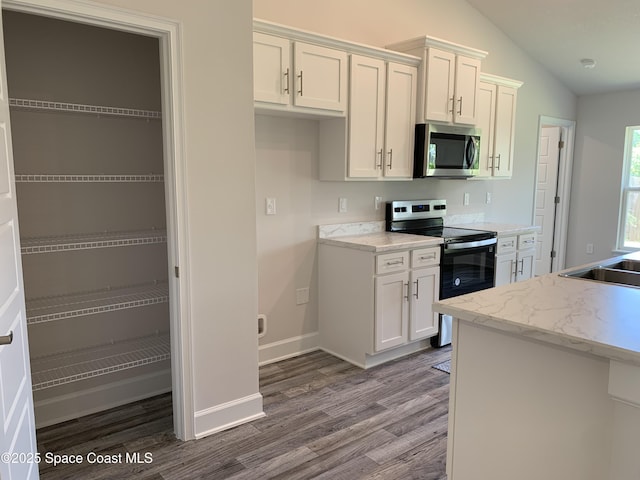 1581 San Filippo Dr SE, Palm Bay, FL 32909 - kitchen with appliances with stainless steel finishes, dark wood-type flooring, lofted ceiling, and white cabinets