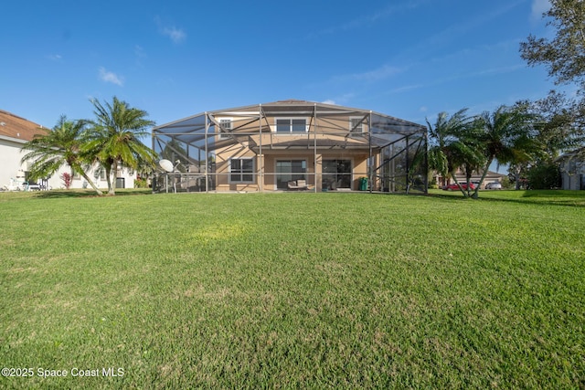 rear view of house featuring a lawn and a lanai