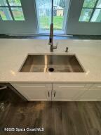 details featuring sink, hardwood / wood-style floors, and white cabinets