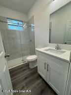 bathroom with vanity, wood-type flooring, toilet, and walk in shower