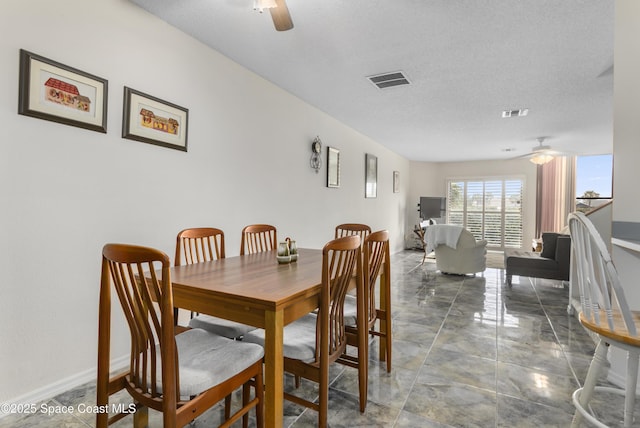 dining area with a textured ceiling and ceiling fan