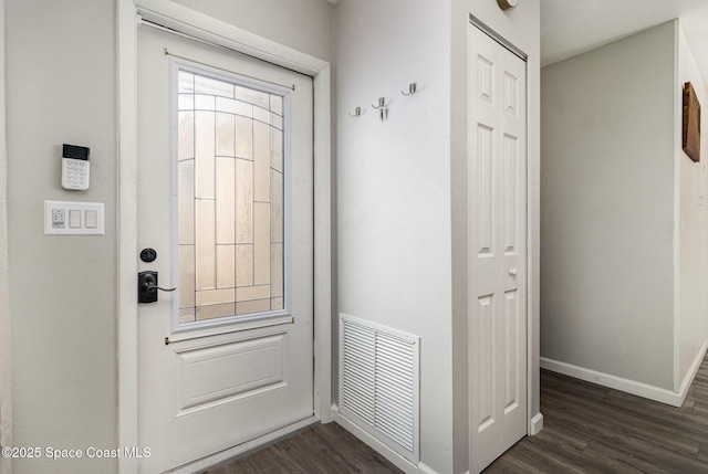 interior space with dark wood-style flooring, visible vents, and baseboards