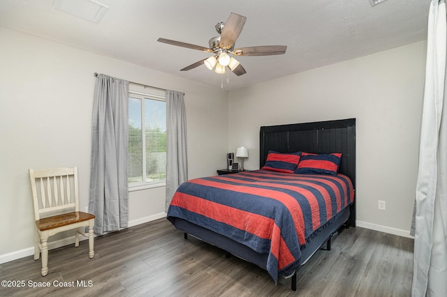 bedroom featuring wood finished floors, visible vents, and baseboards