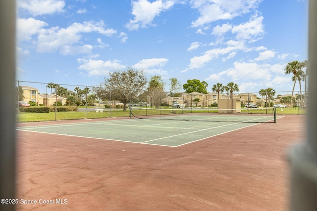 view of sport court with fence and a residential view