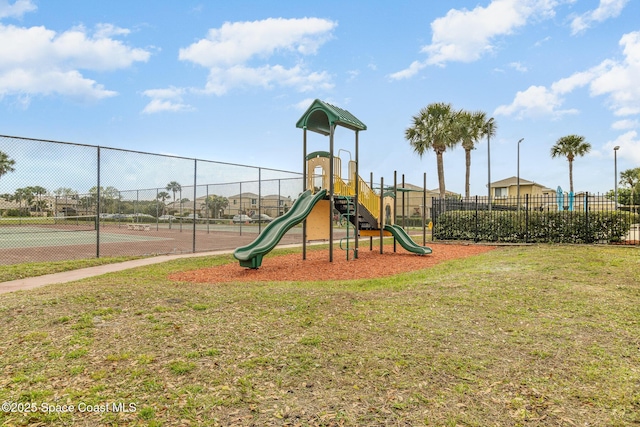 community jungle gym with fence and a lawn