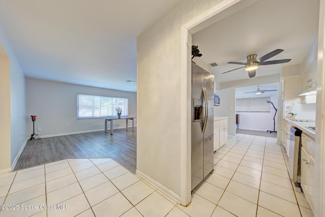 kitchen featuring white cabinetry, stainless steel appliances, and light tile patterned flooring