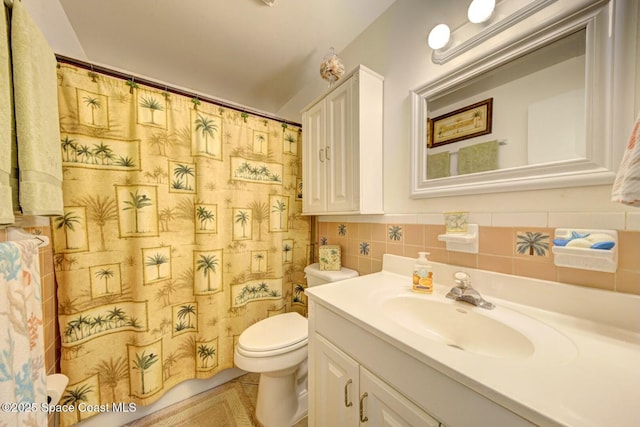 bathroom featuring tile walls, vanity, toilet, and walk in shower