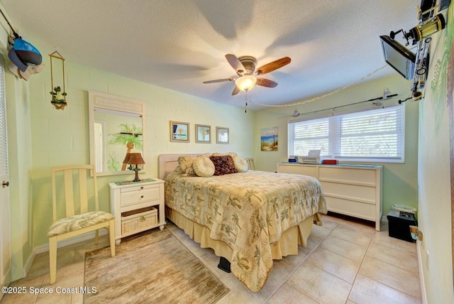 bedroom with ceiling fan, a textured ceiling, and light tile patterned floors