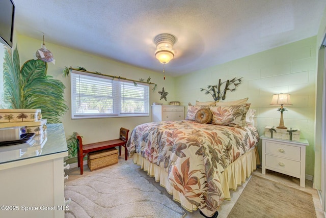 bedroom featuring ceiling fan and a textured ceiling