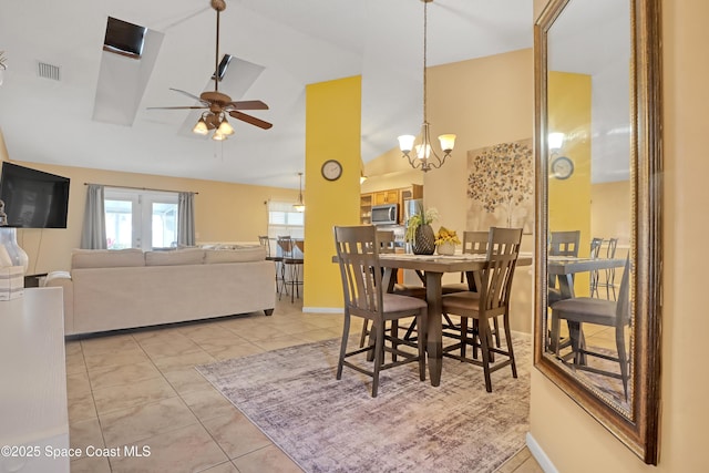 tiled dining area with lofted ceiling and ceiling fan with notable chandelier