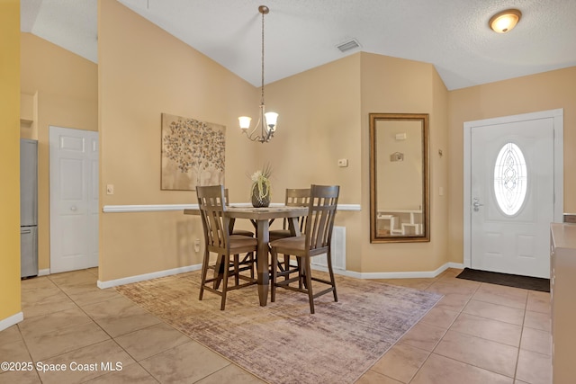 dining room featuring tile patterned floors, vaulted ceiling, a textured ceiling, and a notable chandelier