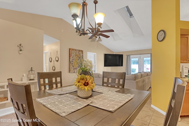 dining area with light tile patterned floors, ceiling fan with notable chandelier, and vaulted ceiling