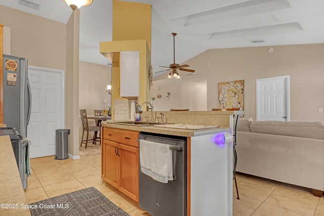 kitchen with light tile patterned flooring, lofted ceiling, sink, appliances with stainless steel finishes, and ceiling fan