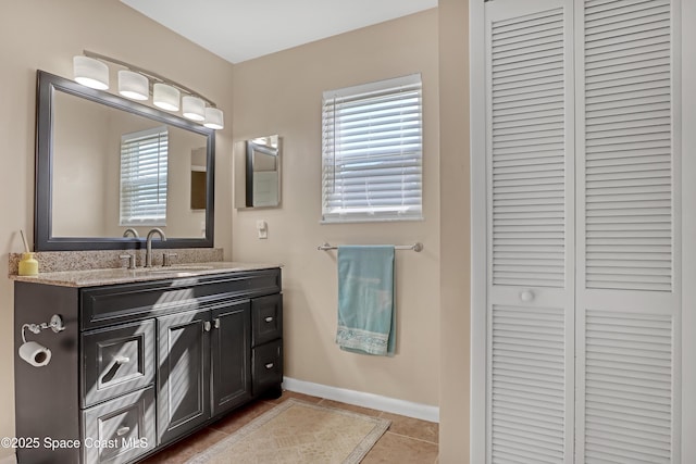 bathroom with tile patterned floors, vanity, and a wealth of natural light