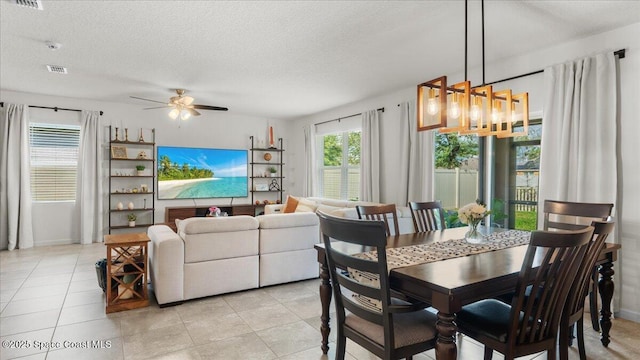 dining area with light tile patterned flooring, ceiling fan, and a textured ceiling