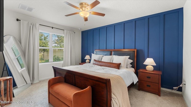 bedroom with light colored carpet, a textured ceiling, and ceiling fan