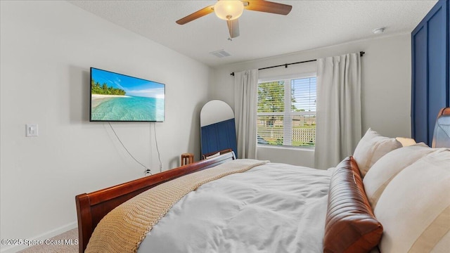 bedroom featuring ceiling fan, carpet flooring, and a textured ceiling