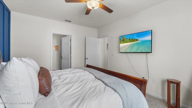 carpeted bedroom featuring ceiling fan and a textured ceiling