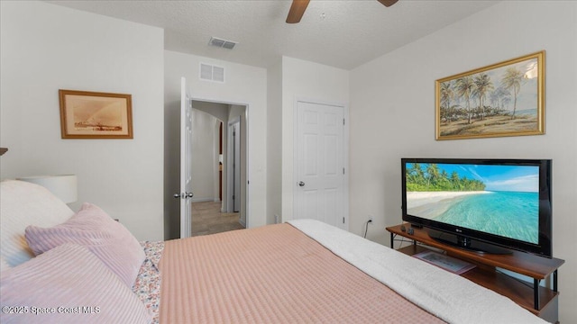 bedroom with ceiling fan and a textured ceiling