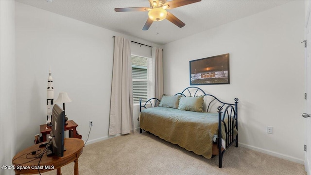 carpeted bedroom featuring ceiling fan and a textured ceiling