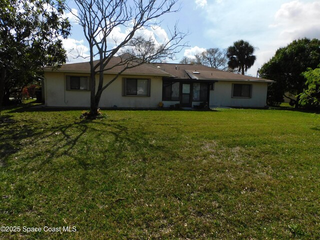 rear view of property featuring a yard