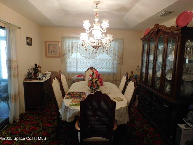 dining room featuring a notable chandelier and a tray ceiling