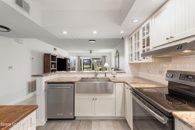 kitchen with kitchen peninsula, white cabinetry, stainless steel appliances, and sink