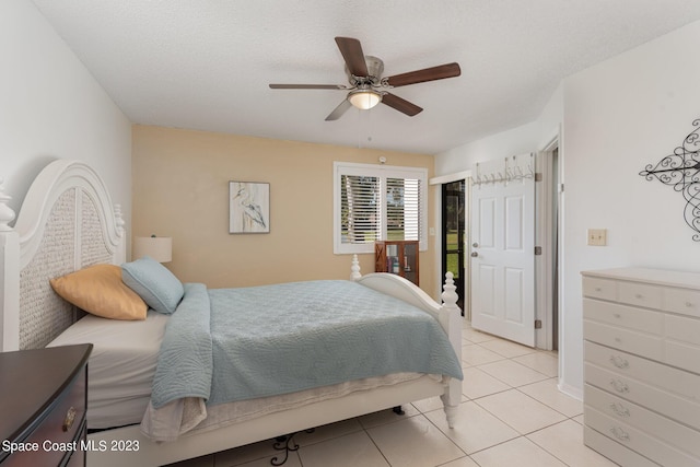 tiled bedroom with a textured ceiling and ceiling fan