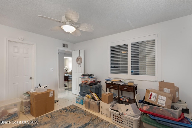 interior space featuring a textured ceiling, ceiling fan, and light tile patterned floors