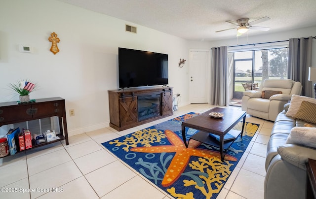 tiled living room featuring ceiling fan and a textured ceiling