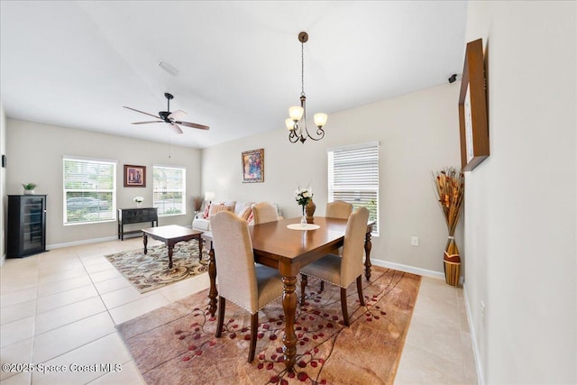 dining room with light tile patterned flooring, beverage cooler, and ceiling fan with notable chandelier