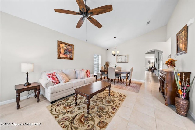 living room with ceiling fan with notable chandelier, vaulted ceiling, and light tile patterned floors