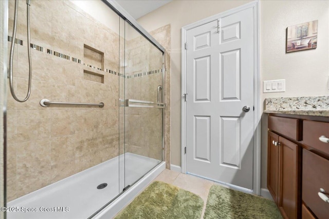 bathroom featuring tile patterned flooring, vanity, and an enclosed shower