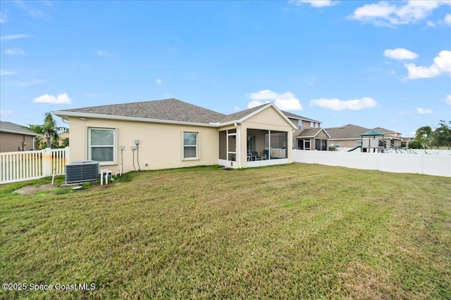 back of property with a yard, central AC, and a sunroom