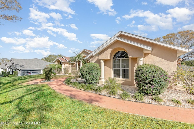 view of front of property with a front yard and stucco siding