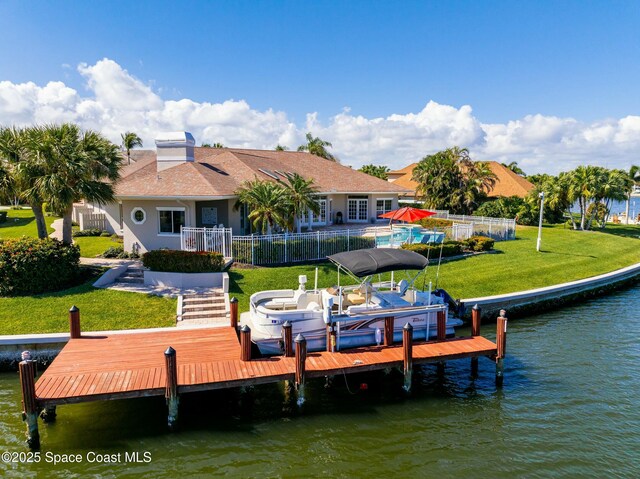 view of dock with a lawn and a water view