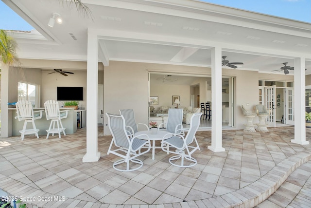 view of patio featuring exterior bar and ceiling fan