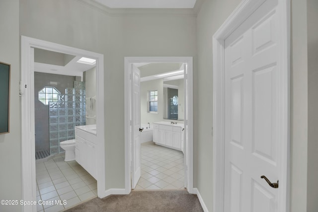 bathroom with tiled shower, tile patterned floors, toilet, crown molding, and vanity