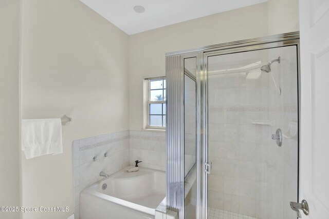 bathroom featuring independent shower and bath