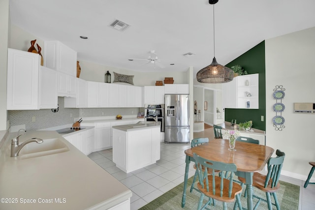 kitchen featuring pendant lighting, sink, decorative backsplash, a kitchen island with sink, and stainless steel refrigerator with ice dispenser