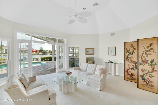 living room with ceiling fan, light colored carpet, and high vaulted ceiling